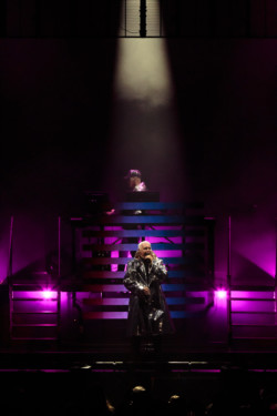 Neil Tennant of Pet Shop Boys performs in a silver metallic raincoat. Chris Lowe is seen in the background under a spotlight at Budweiser Stage in Toronto, CANADA