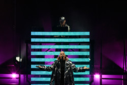 Neil Tennant of Pet Shop Boys performs in a silver metallic raincoat. Chris Lowe is seen in the background at Budweiser Stage in Toronto, CANADA