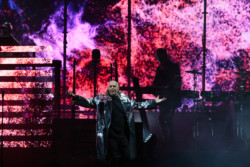 Neil Tennant of Pet Shop Boys performs in a silver metallic raincoat in front of a bright LED screen at Budweiser Stage in Toronto, CANADA