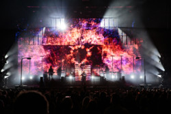 Pet Shop Boys perform for a large crowd in front of an LED screen displaying explosive bright colours at Budweiser Stage in Toronto, CANADA