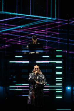 Neil Tennant of Pet Shop Boys performs in a silver metallic raincoat and sunglasses. Chris Lowe is seen in the background at Budweiser Stage in Toronto, CANADA